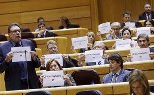 El portaveu de CiU, Josep Lluís Cleries, i el conjunt del grup ahir al Senat en el moment d'exhibir el cartell sobre el 9-N Foto: EFE.